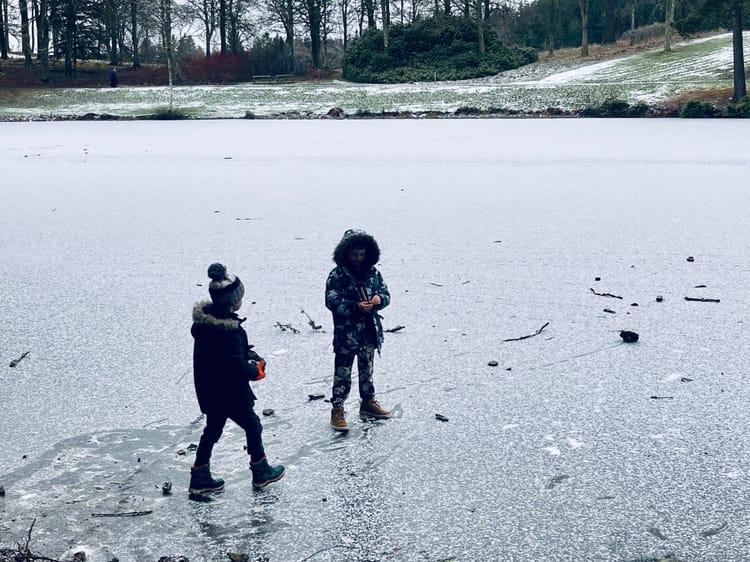 Two boys standing on a frozen loch