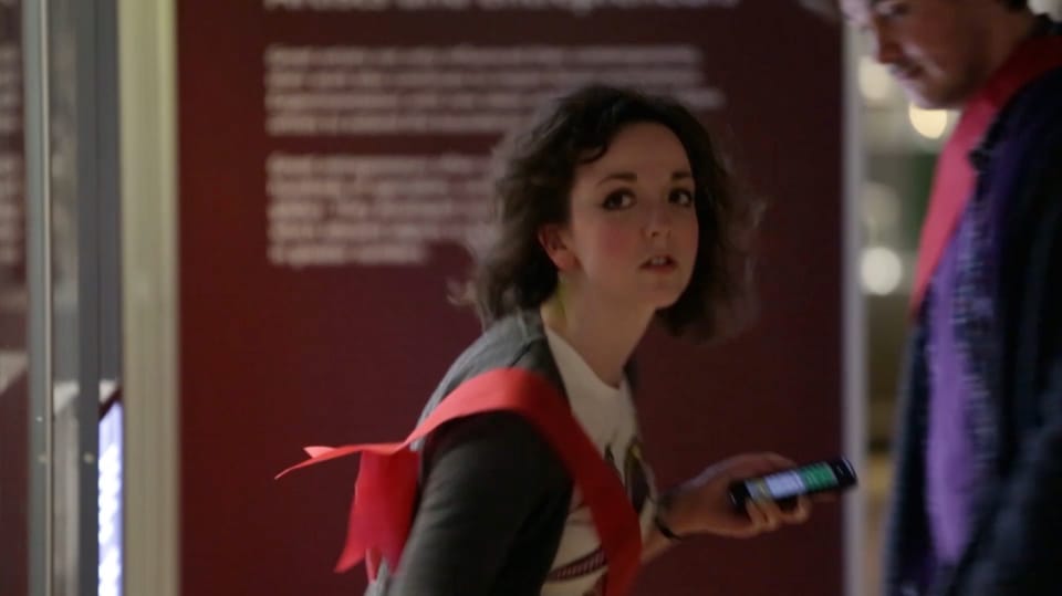A woman clutches a mobile phone while playing Capture the Museum in the National Museum of Scotland.