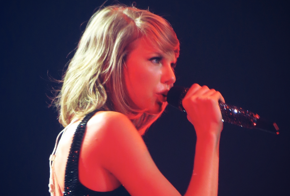 Taylor Swift, holdind a microphone